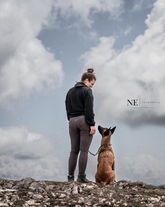 Svenja und ihr Malinois stehen nebeneinander auf einem Felsplateau und schauen sich an